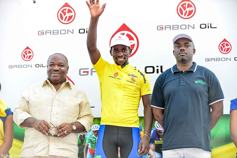 Team Rwanda's Joseph Areruya is joined on the podium by Gabonese President, Ali Bongo Ondimba (L) after he was crowned the winner of the 2018 edition of La Tropicale Amissa Bongo y....
