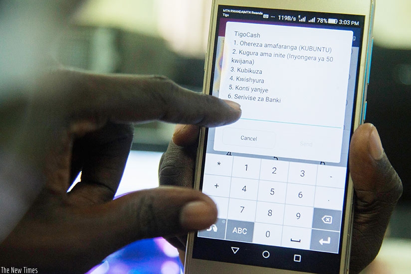 A customer uses TigoCash. The merger means that Airtel now has a combined customer base of 5.05 million users. (File)