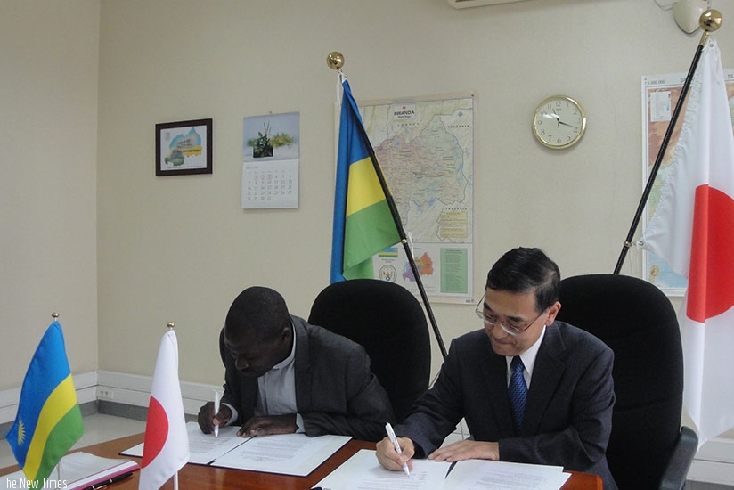Japanese Ambassador Miyashita and the headmaster of St. Joseph Nzuki Vocational Training Center, Father Hakizimana, sign the grant agreement. rn (Sam Ngendahimana)