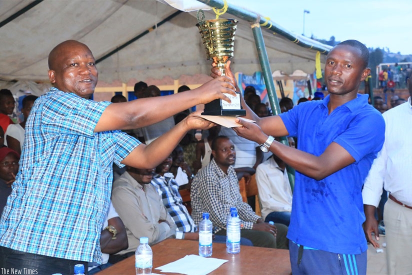 Police captain, Dismas Turatsinze hands over the trophy to the Deputy IGP in charge of Administration and Personnel, Juvenal Marizamunda