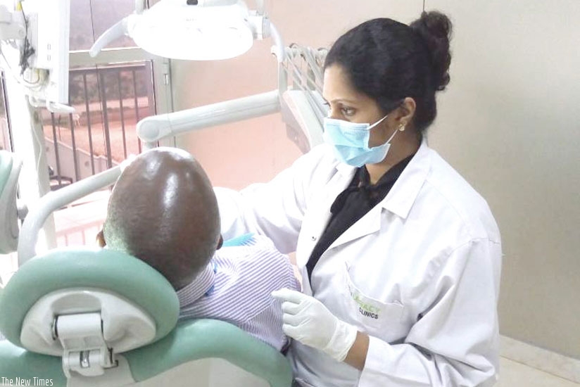 Dr Dona Sanju attends to a patient with a dental problem at Legacy Clinic in Kigali. / Diane Mushimiyimana.