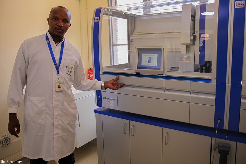 Innocent Mudahemuka, a medical scientist explains, how the QIA Symphony machine works . The machine is used for purification of Nucleic Acids (DNA) .Timothy Kisambira.