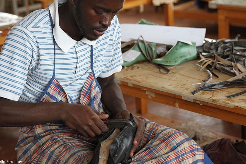 A worker makes a shoe at Masaka Business Incubation Center. File