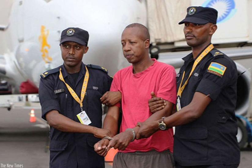 Police officers arrest Genocide suspect Jean Twagiramungu at Kigali International Airport on his extradition from Germany in August last year. File.