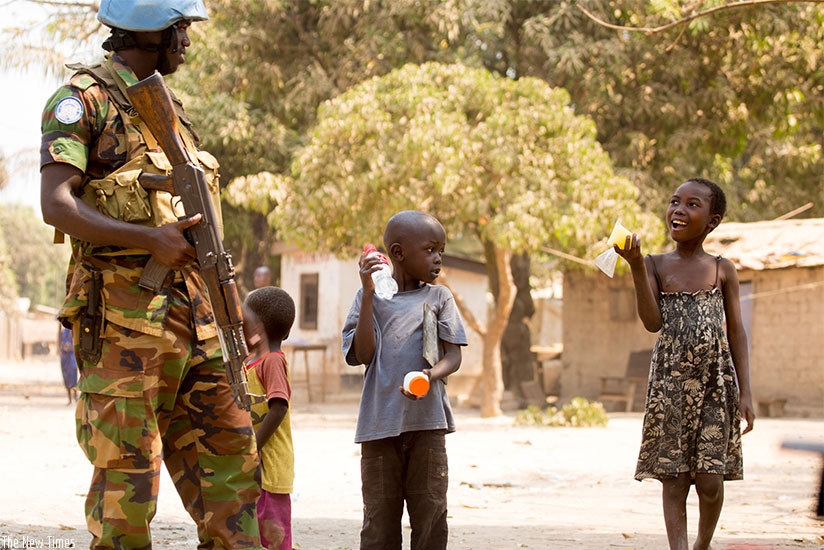 A Rwandan peacekeeper chats with children in Central Africa Republic. Timothy Kisambira.