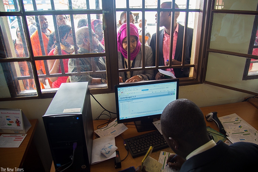 Travellers from Burundi to Rwanda present their documents to immigration officials at Nemba border post January 06 2015. File.