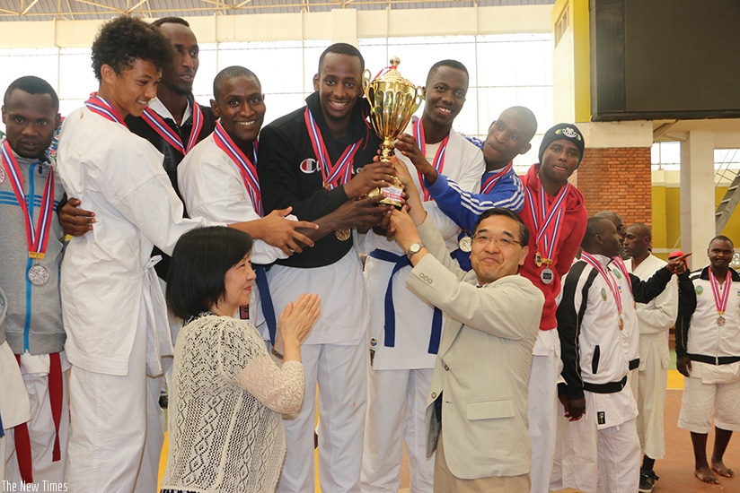 Vanily Ngarambe (in black sweater) seen here receiving the trophy from Japanese Ambassador at this year's Ambassador's Cup last month. Courtesy