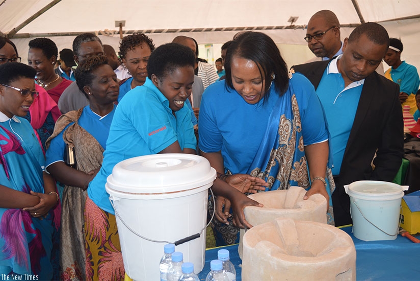 Minister Nyirasafari examines a water filter made from clay by a woman enterpreneur in Muhanga. Jean d'Amour Mbonyinshuti.