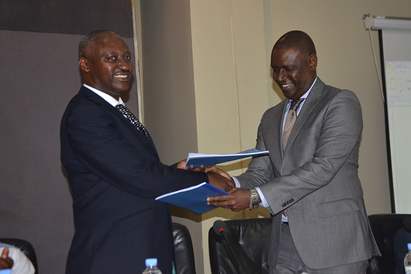 Robert Bafakulera the incoming PSF chairman exchanges documents with the outgoing chairman Benjamin Gasamagera. Courtesy