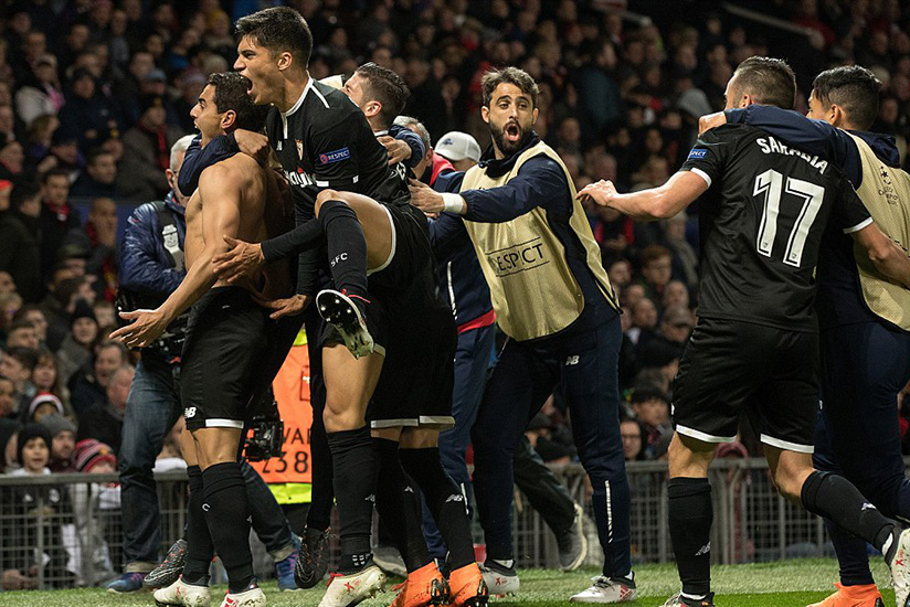 Sevilla's entire team and a number of their substitutes pile into a celebration in the corner following their second goal.