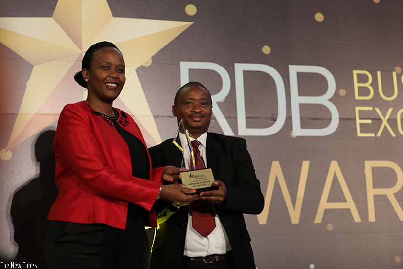 Chief Executive Officer of Rwanda Development Board gives an award of emerging investor of the year to Saudi Hitimana Human Resource manager of C&H.