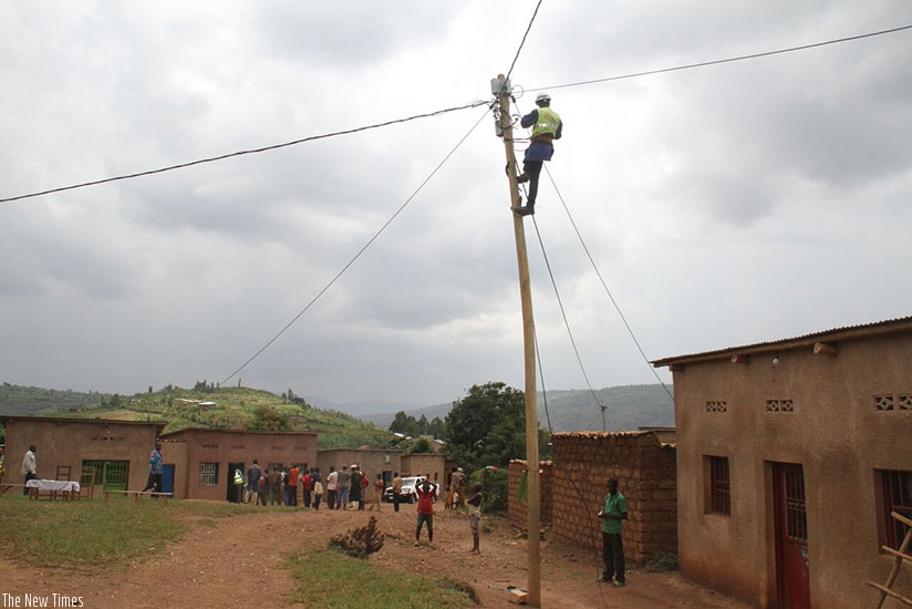 An EUCL worker connects residents onto the national grid in Nkuzuzu Cell, Bumbogo Sector in Gasabo District. (Photos by Timothy Kisambira)