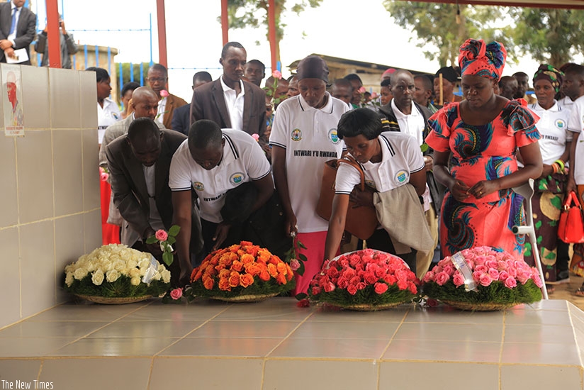 Survivors of the March 18, 1997 nighttime attack on ES Nyange school in Ngororero District lay wreaths on the grave of one of their former classmates, Valens Ndemeye, who was kille....