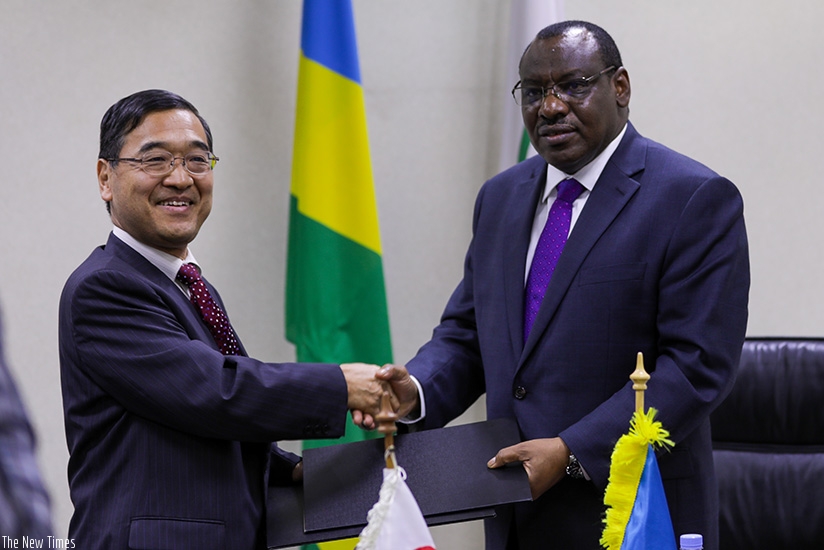 Amb. Miyashita and Minister Gatete exchange documents after signing the deal in Kigali yesterday. Timothy Kisambira. 