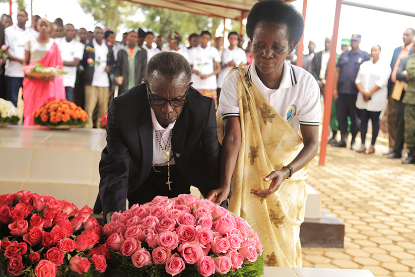 Parents of Imena Hero Marie Chantal Mujawamahoro lay a wreath on the grave of their daughter. Sam Ngendahimana.