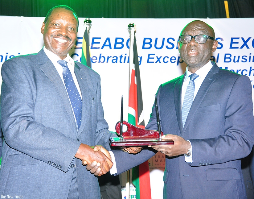 Karera (right) receives the award from Jim Kabeho, the EABC chairman. / Peterson Tumwebaze.