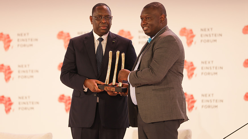 Senegal President Macky Sall  (L) gives an award  to Professor Abdoulaye Banire Diallo from Guinea. (Timothy Kisambira)