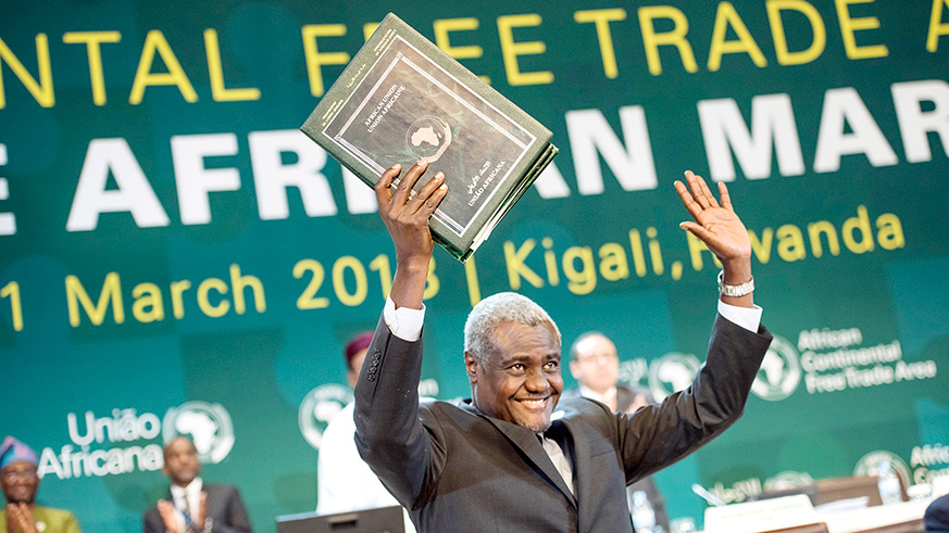 African Union Commission Chairperson Moussa Faki Mahamat shows off the three treaties after they were signed by Heads of State and representatives in Kigali last week. 30 of the 55 African countries signed the protocol on free movement. (Courtesy)