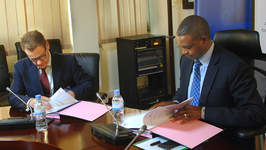  I&M Bank CEO Bairstow (left) and BRDu2019s Rutabana sign the deal. BRD signed agreements to provide four banks funds for on-lending to private sector in support of efforts to scale up access to renewable energy solutions. / Peterson Tumwebaze.