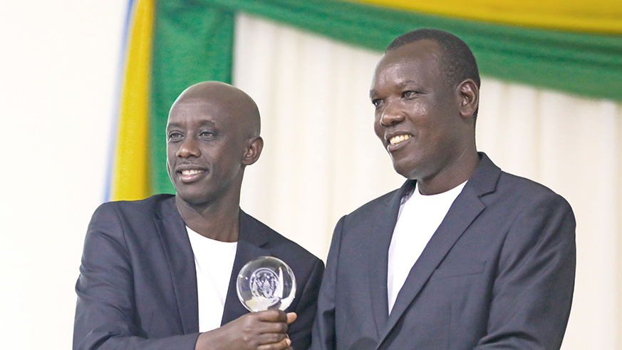 Local Government Minister Francis Kaboneka (L) gives an award to Eugene Kayiranga Muzuka, the mayor of Huye District. Timothy Kisambira. 