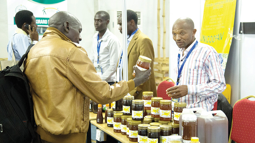 Innocent Nzabonimpa (right), the president of beekeeping and honey processing cooperative COPANYAKA at the cooperatives expo. Nadege Imbabazi.