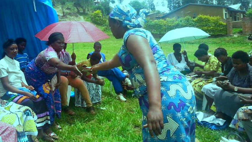 Esther Mukamashyaka distributes money to the group members. 