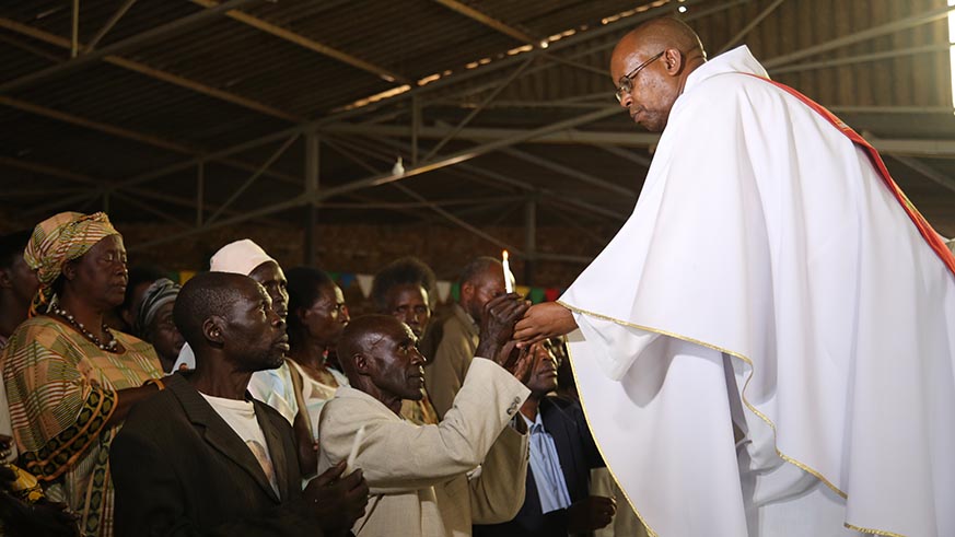 Father Janvier Gahonzire from Butare Diocese passes a candle to Boniface Hakizimana and others after they reconciled with the survivors whose members they killed. Jean d'Amour Mbonyinshuti