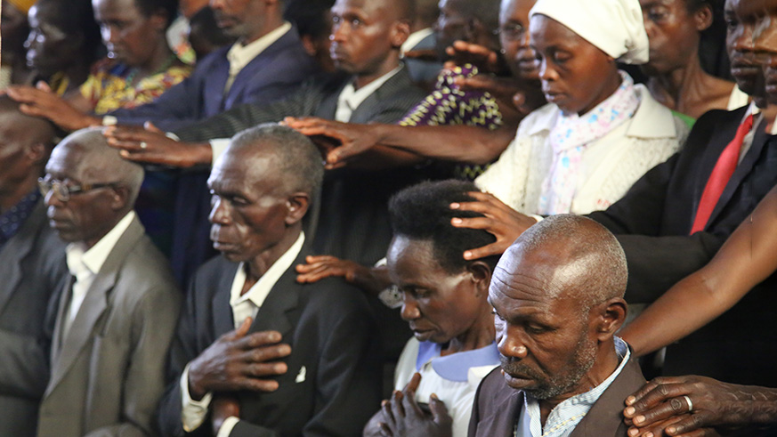 Genocide convicts who served their sentences kneel down as survivors pray for them during Mass at Ruhango Catholic Parish in Huye District. Jean du2019Amour Mbonyinshuti. 