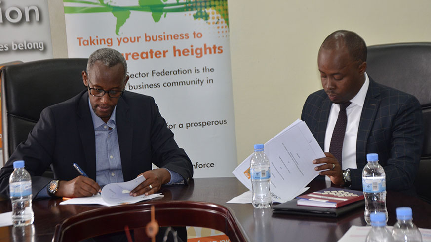 Ruzibiza (left) and Murenzi sign the agreement at PSF Headquarters in Gikondo. Courtesy.