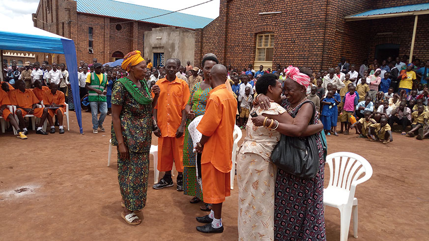 Twagiramariya and her sons hug and chat with Genocide survivors at Kiziguro Parish last week.
