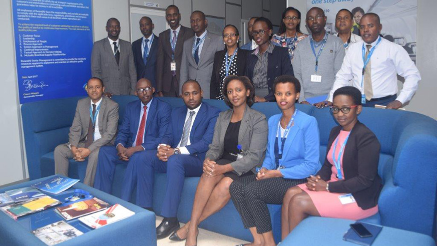 Senior managers at the airline join the incoming and outgoing CEOs in a group photo after Makolo took over from Ndagano. State minister Uwihanganye is third from left (seated). / Courtesy