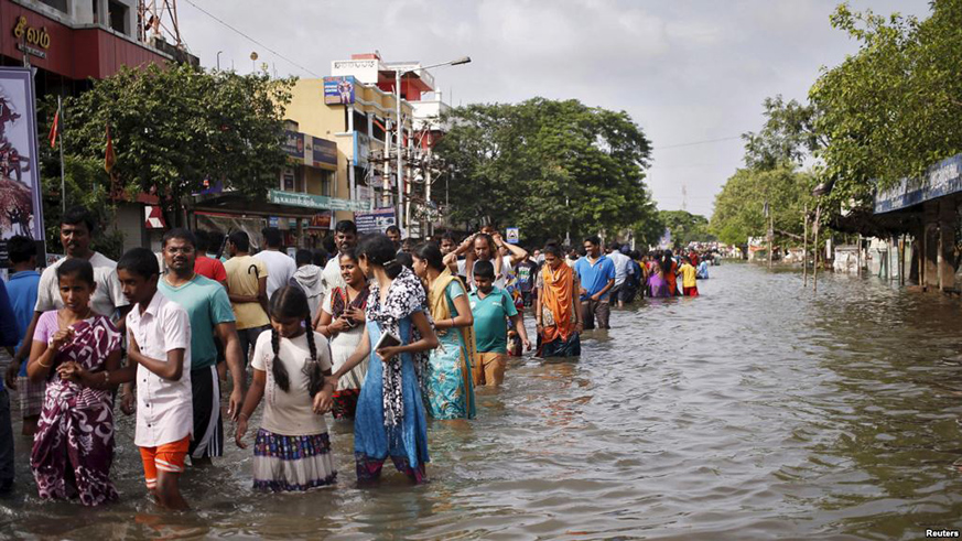 Residents wade through a flooded street as they evacuate their homes in Chennai, in the southern state of Tamil Nadu, India, Dec. 3, 2015. Net. 