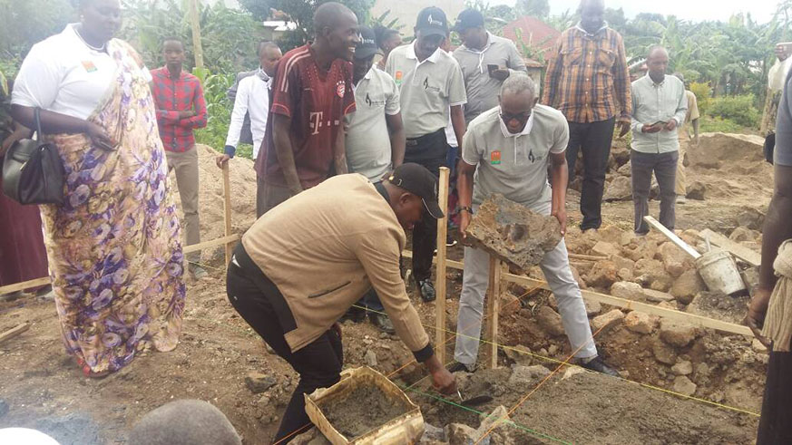 PSF CEO Stephen Ruzibiza (with a stone) and Eric Gishoma, the vice chairman, PSF, during the groundbreaking of the construction of the model village for survivors in Rubavu. Courtesy.
