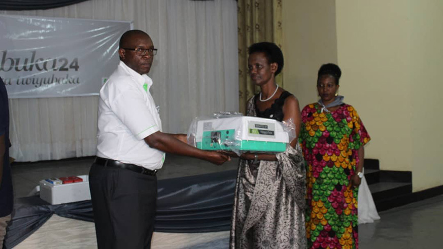 KCB Bank Rwanda Managing Director George Odhiambo (left) hands over some of the medical  equipment to AVEGA leaders. Courtersy.