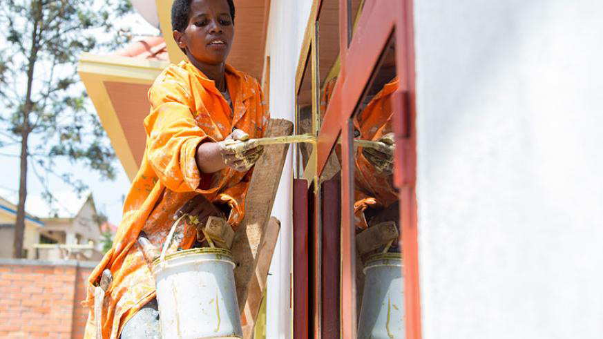 Jeanne Uwamahoro paints a house in Gisozi, Kigali. 
