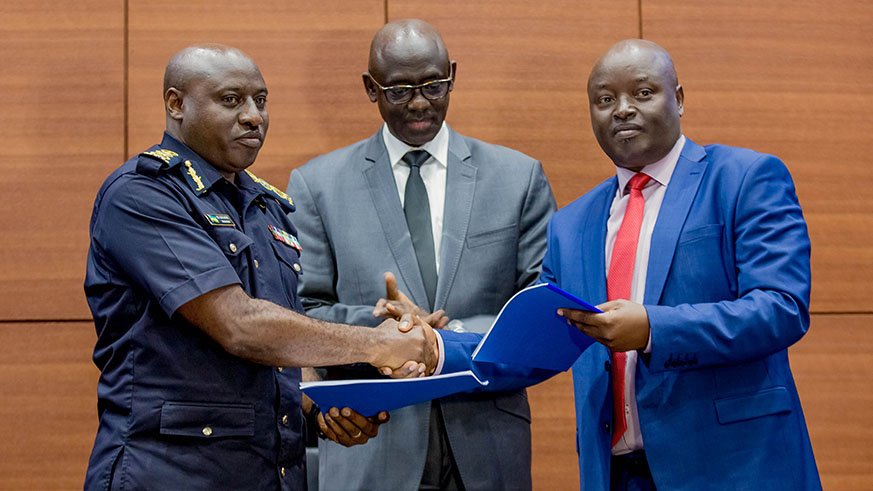 Inspector General of Police Emmanuel Gasana (left) hands over the CID function to RIB Director General Jeannot Ruhunga yesterday during the launch of the bureau as Minister for Justice Johnston Busingye (centre) looks on. Nadege Imbabazi.
