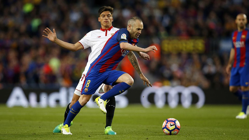 Barcelona captain Andres Iniesta dribbles past a Sevilla player. Sevilla will be hoping they can cause an upset and win the Copa del Rey. Net photo