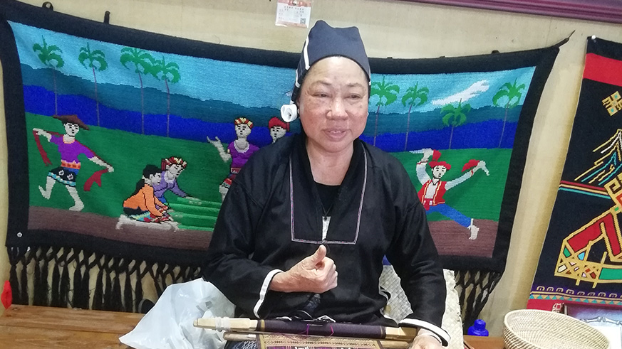 A Li woman doing embroidery. This is a unique skill where they only use sticks and other wooden material to make cloth embroideries of different kinds