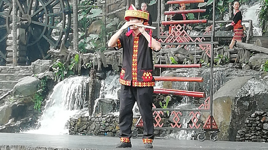 A man blows a musical instrument using his nose.