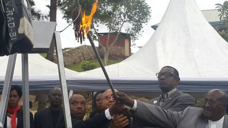 Amb. Mugambage (2nd right) is joined by different officials, including Frank Rusanganwa (R), an elder from the Rwandan community in Uganda, to light a flame of hope in Kasensero. Courtesy. 