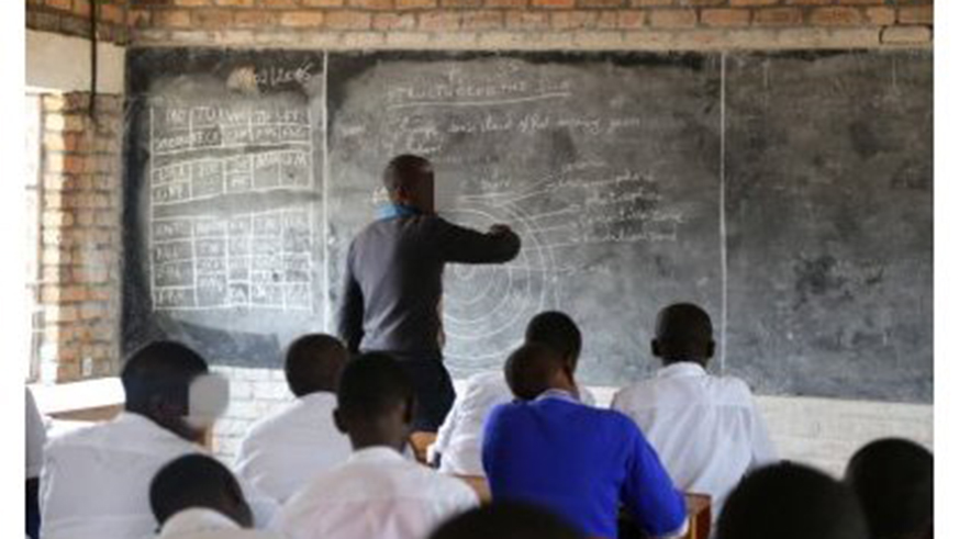 A teacher writing on the black board