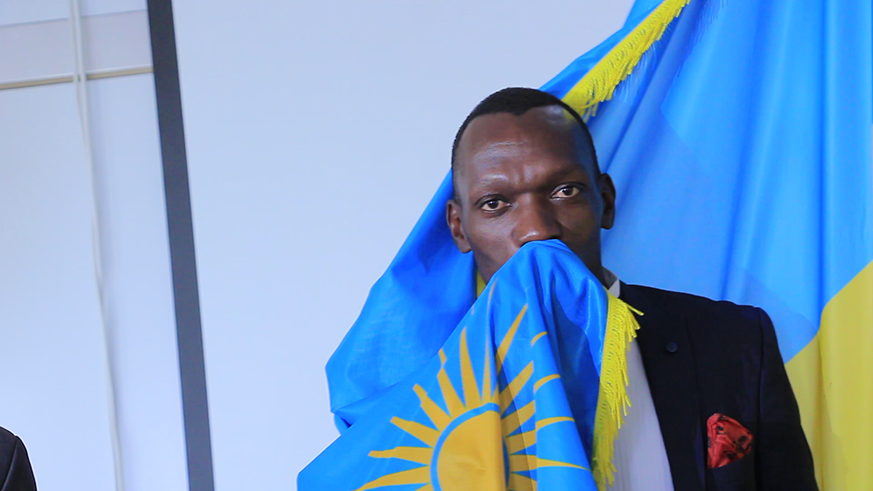 Kagere kisses the Rwandan flag after he was sworn in at the City Hall yesterday. Rabin Imani.