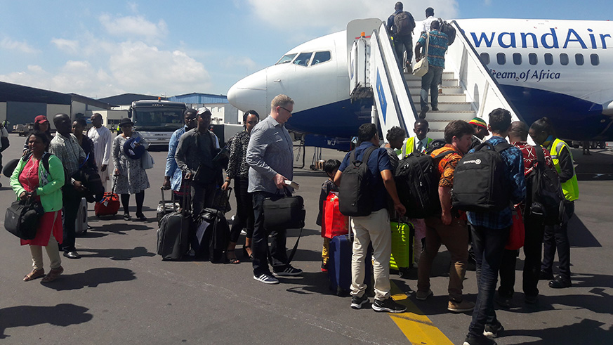 Passengers board Abuja-bound RwandAiru2019s Boeing 737-700 plane at Kigali International Airport as the national carrier launched its maiden flight to the Nigerian capital, yesterday. Julius Bizimungu