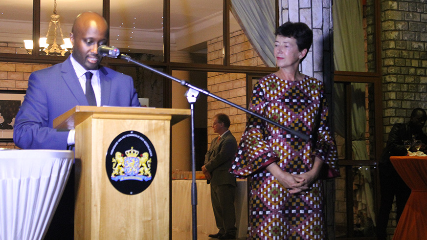 Olivier Nduhungirehe, the Minister of State in the Ministry of Foreign Affairs, Cooperation and East African Community speaks during celebrations to mark the Dutch Kingu2019s Day on Friday as Dutch envoy to Rwanda, Fredrique de Man, looks on. Courtesy.