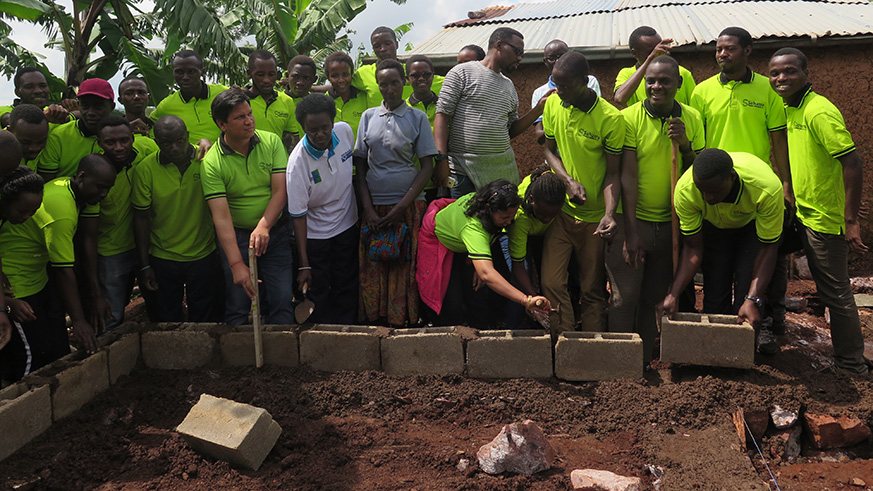 Agnes Karubibi (standing centre), the beneficiary, with staff from RG Consult and partners, during the construction of her house last Saturday. Photos by Eddie Nsabimana.