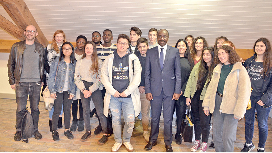 Amb. Franu00e7ois Xavier Ngarambe (in a tie) poses for a photo with a group of students and their teachers in Geneva. Courtesy. 