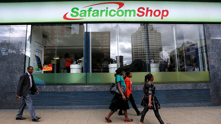 People walk past a Safaricom shop in Nairobi. Net photo.