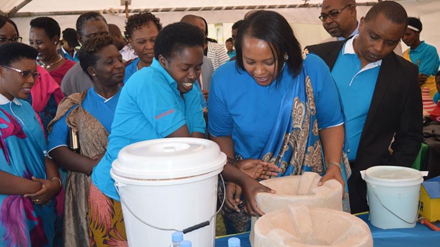 Minister Nyirasafari examines a water filter made from clay by a woman enterpreneur in Muhanga. File.