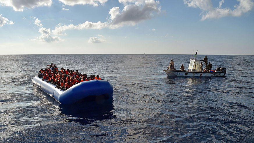 Refugees sit on a rubber boat alongside a Libyan coast guard patrol. Net.