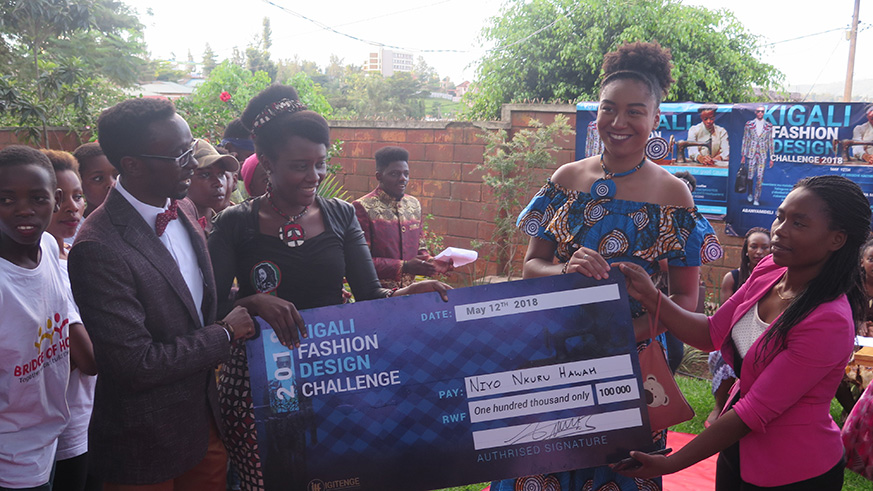 Hawa Niyonkuru (second left) receives her award after  she emerged  the winner of the fashion event.
